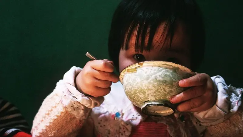 Niño japonés aprovechando hasta la última porción de comida, práctica cotidiana ligada al concepto Mottainai.